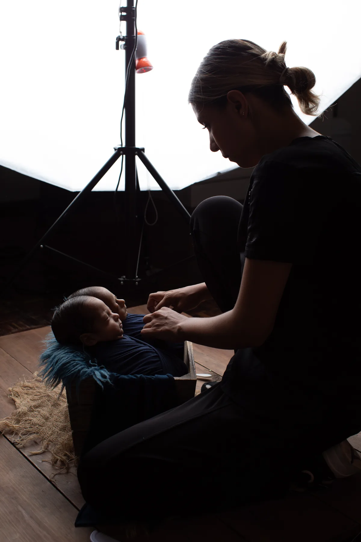 Reyna acomodando con cuidado a gemelos recién nacidos durante una sesión newborn en el estudio Bambuky, Querétaro