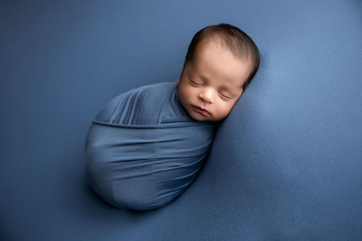 Fotografía newborn profesional Querétaro - pose lateral en traje crema